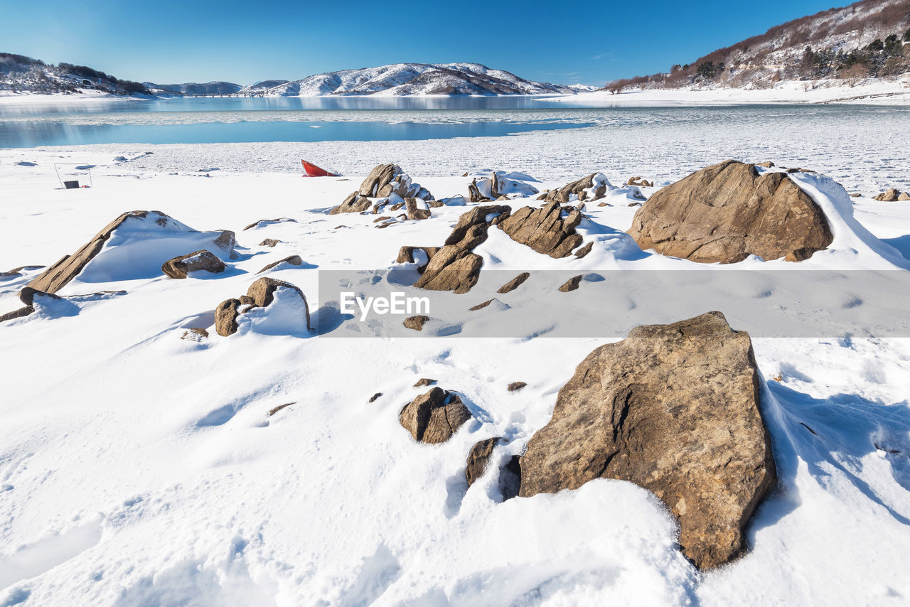  view of snow covered shore against blue sky