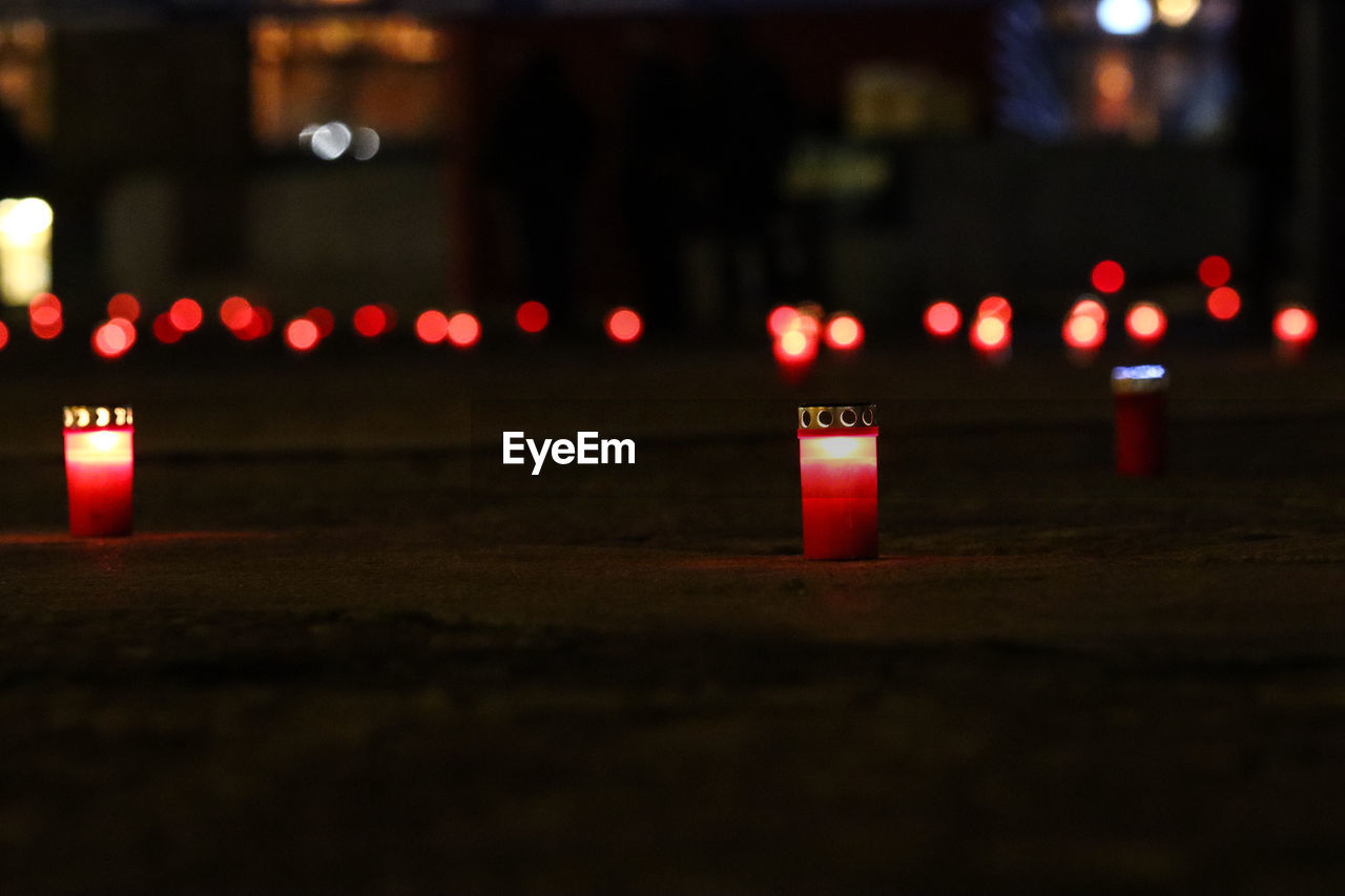 CLOSE-UP OF LIT CANDLES ON FIRE