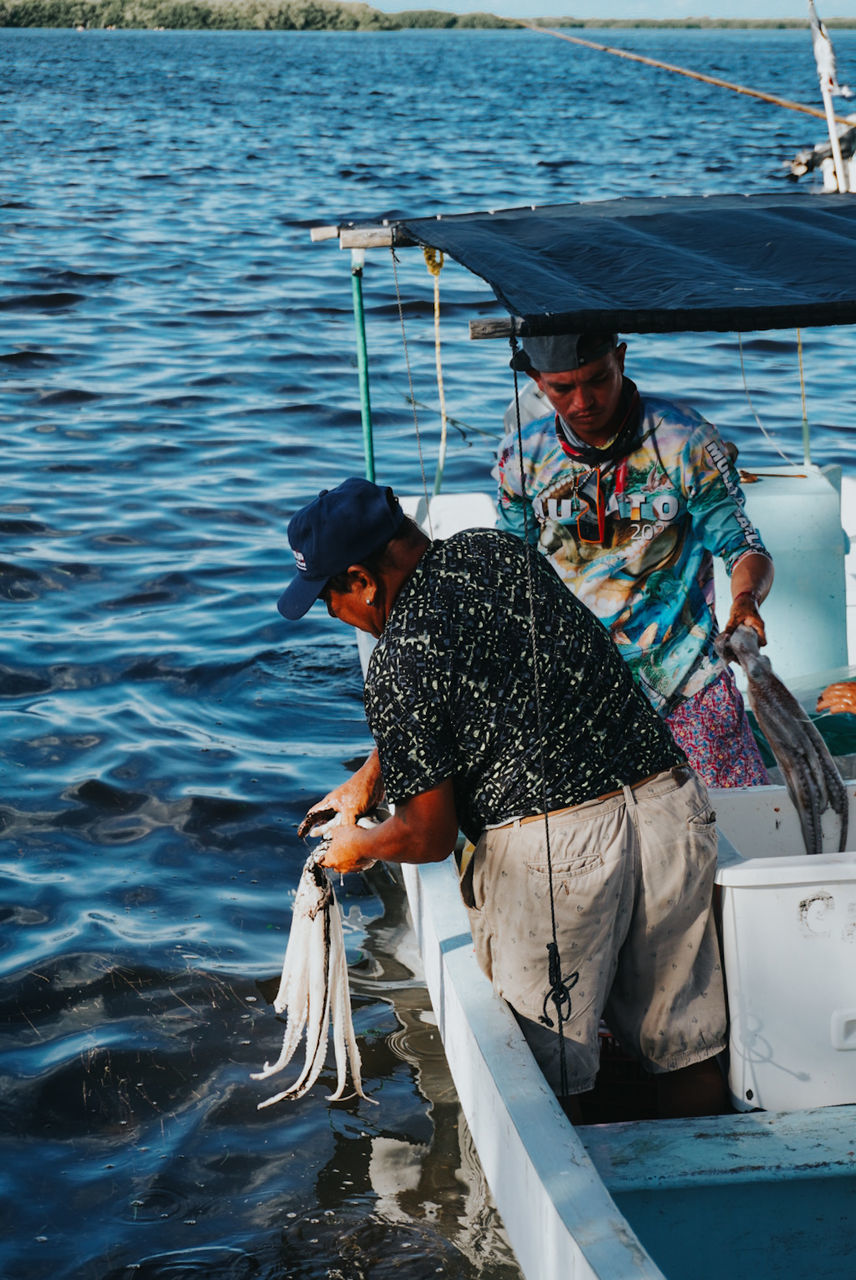 water, nautical vessel, sea, transportation, men, adult, mode of transportation, nature, fishing, occupation, two people, day, fisherman, boat, outdoors, fish, boating, fishing industry, ship, sailing, vehicle, clothing, travel, three quarter length, animal, lifestyles, hat, mature adult