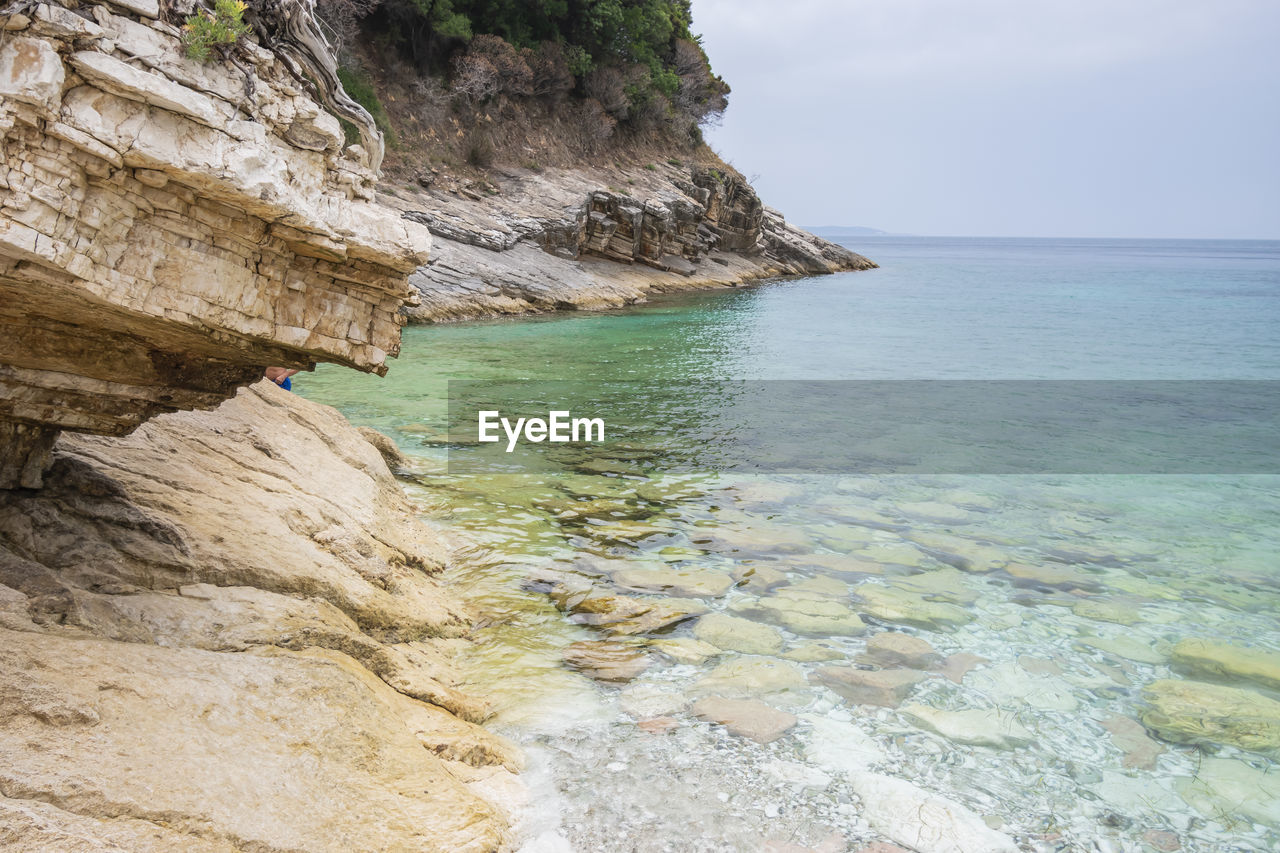 ROCK FORMATIONS IN SEA AGAINST SKY