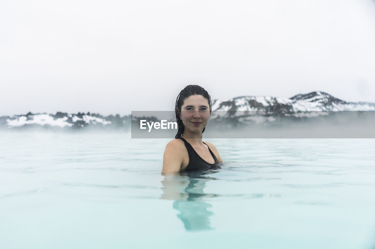Portrait of smiling young woman in hot spring