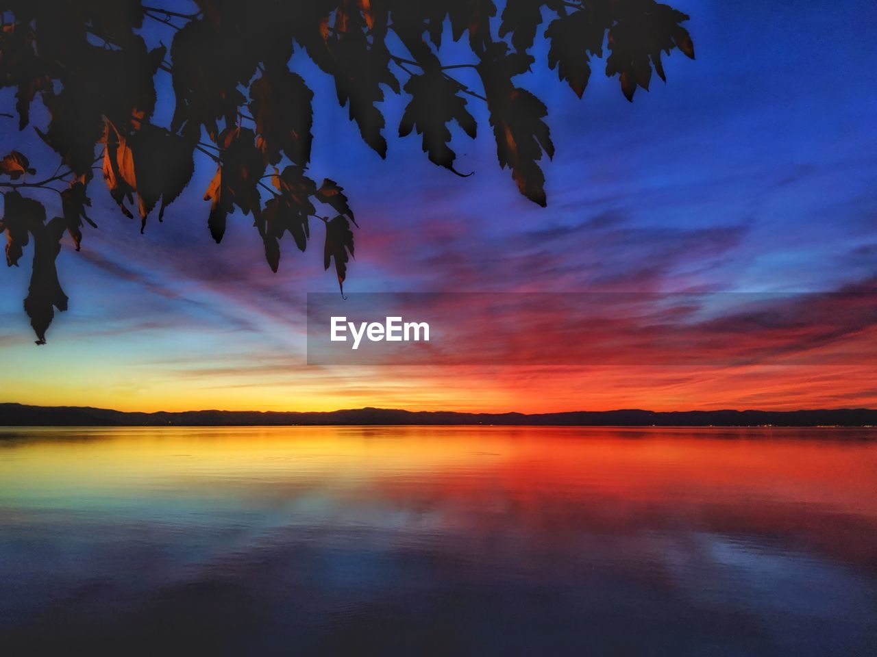 Scenic view of lake against sky during sunset