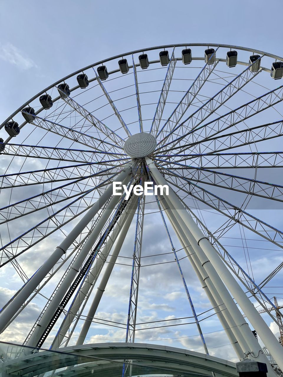 ferris wheel, amusement park, amusement park ride, arts culture and entertainment, sky, architecture, built structure, recreation, no people, nature, low angle view, carnival, geometric shape, traveling carnival, travel destinations, circle, outdoors, day, shape, leisure activity, travel, city, large, wheel, transportation, cloud, fun