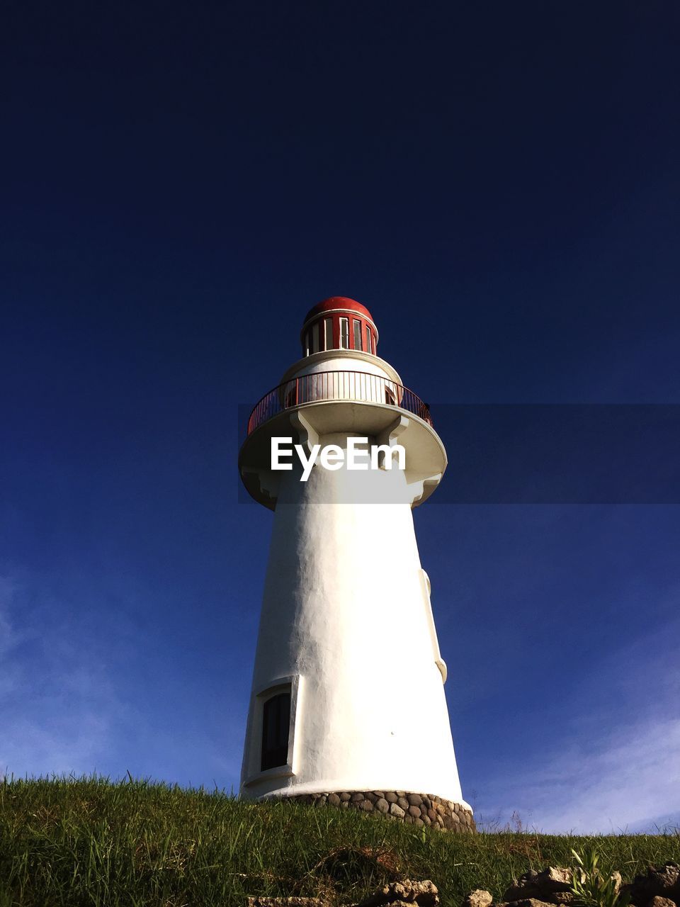 LOW ANGLE VIEW OF LIGHTHOUSE AGAINST BUILDING AND SKY