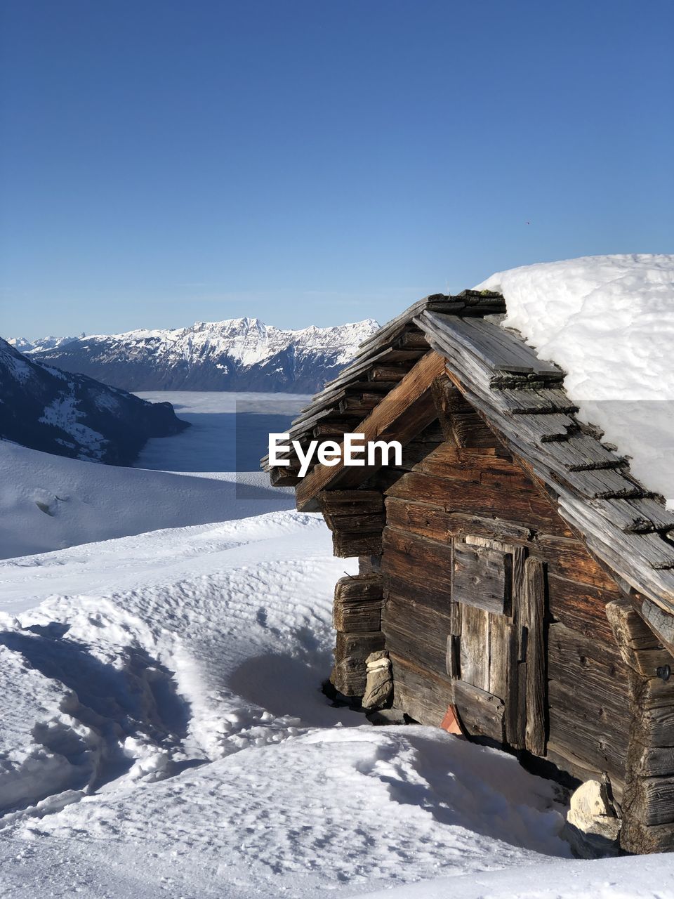 BUILDING COVERED WITH SNOW AGAINST SKY