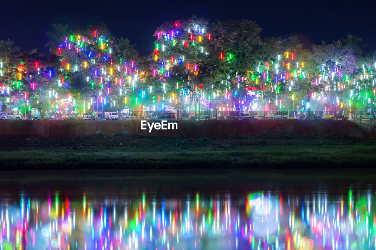 Colorful illuminated rainbow over water at night