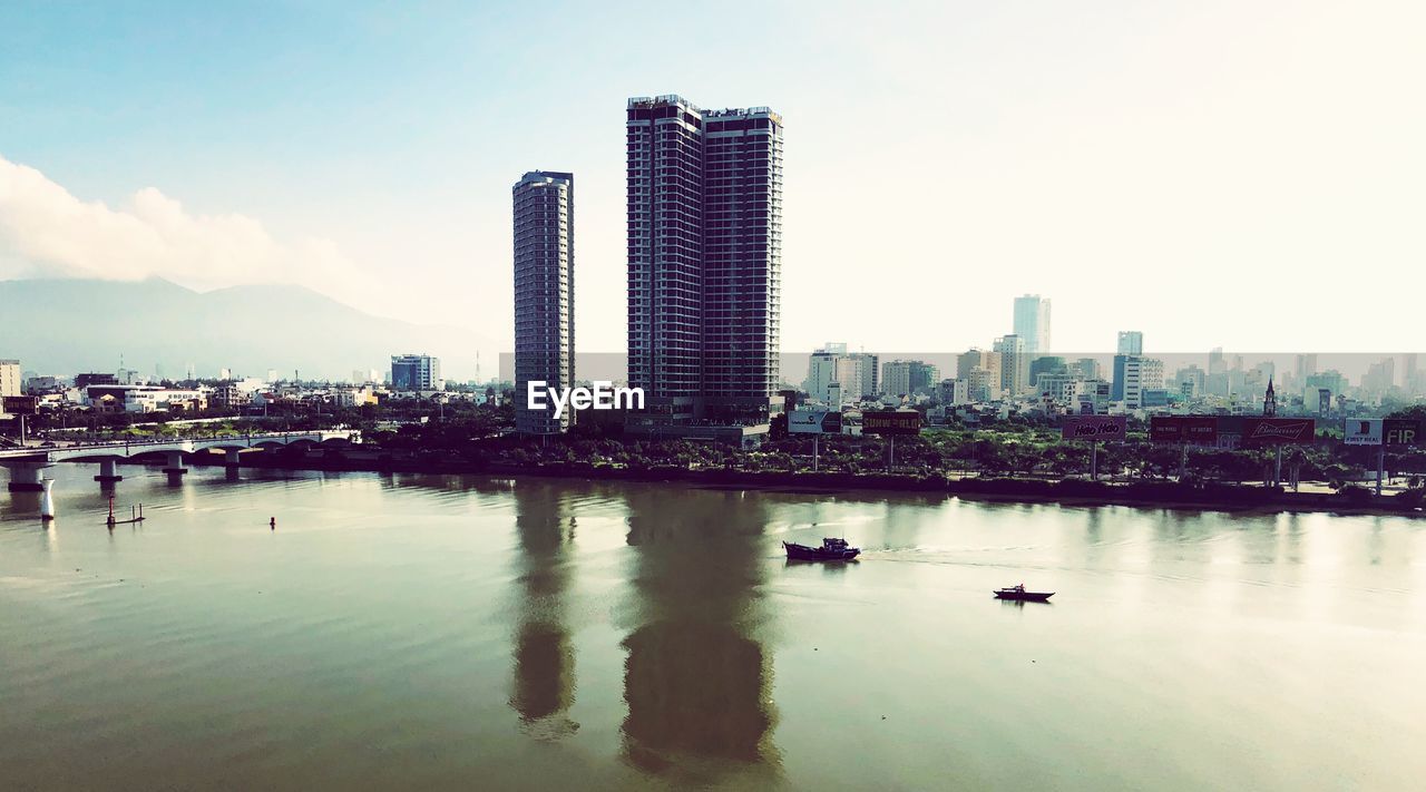 Scenic view of river and buildings against sky