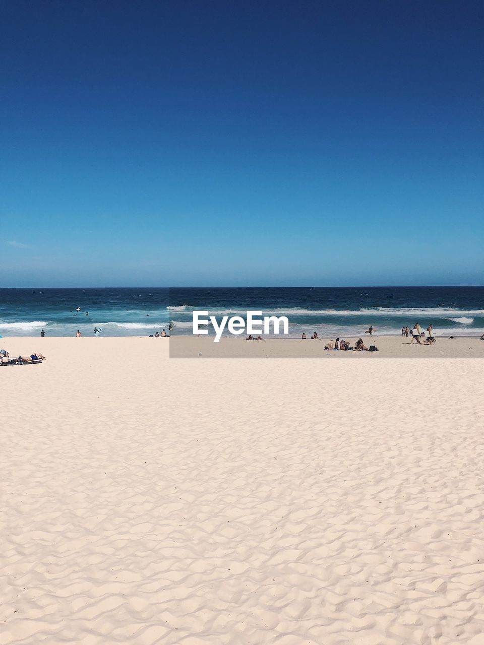 Scenic view of beach against clear blue sky