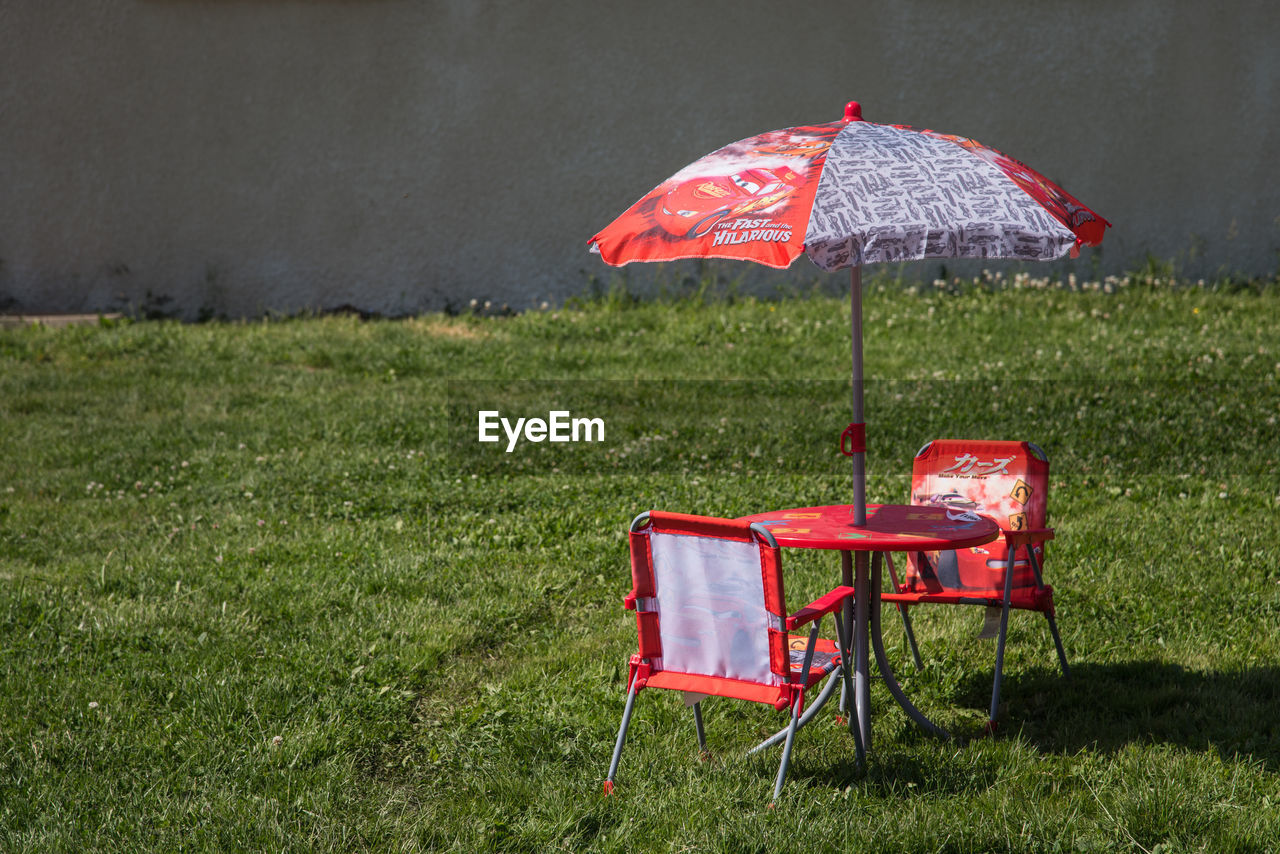 RED CHAIRS ON TABLE AT GRASS