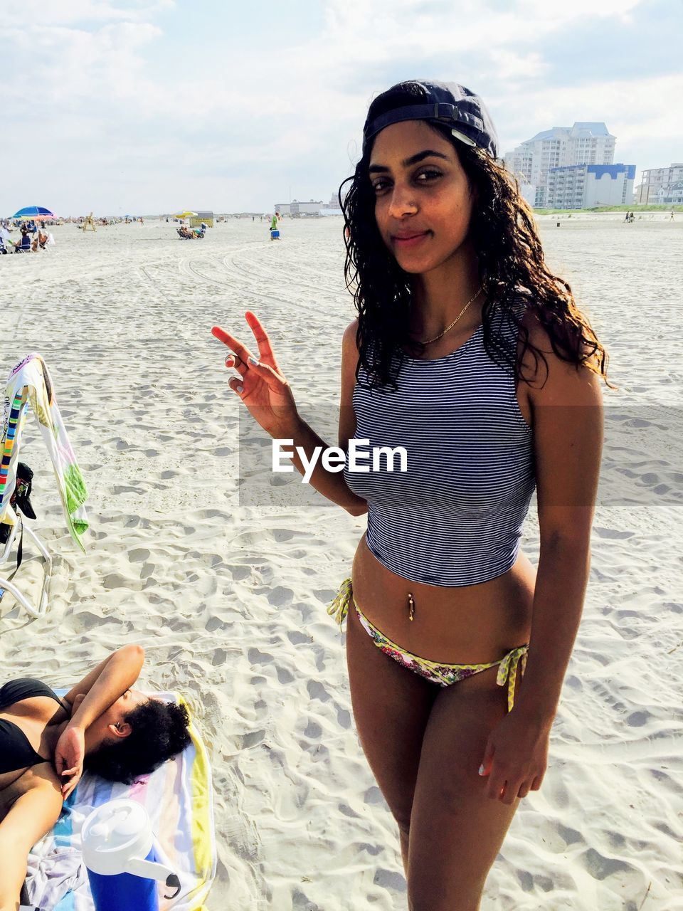 BEAUTIFUL YOUNG WOMAN WEARING SUNGLASSES ON BEACH