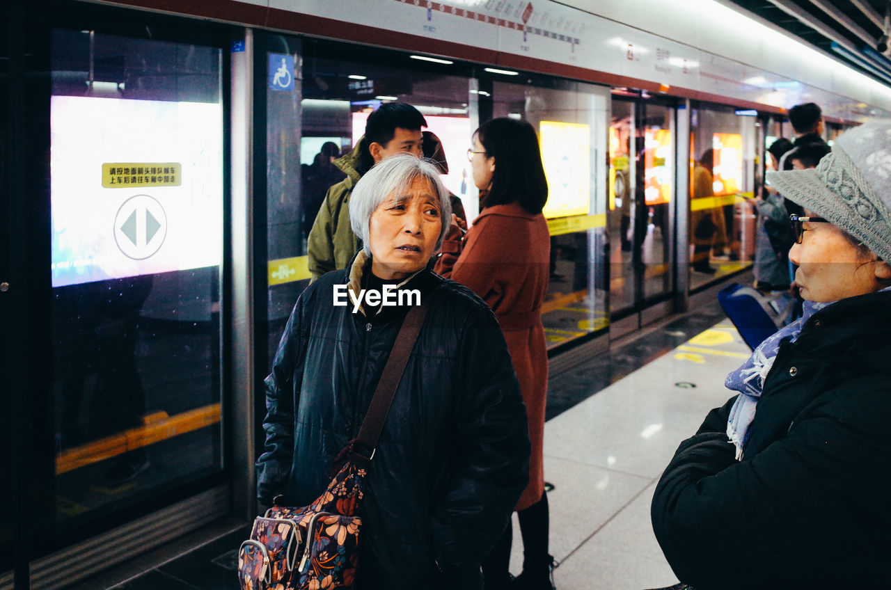 PEOPLE WAITING TRAIN AT RAILROAD STATION