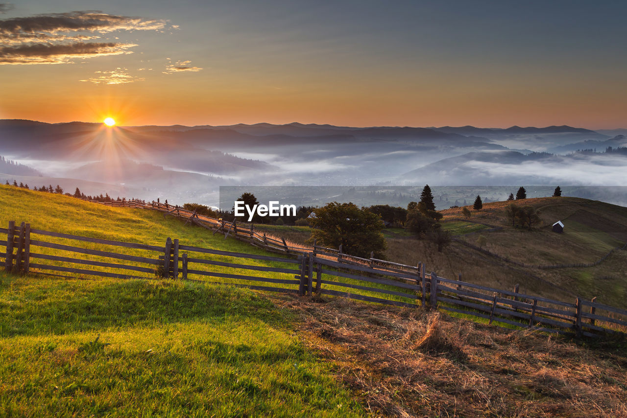 Scenic view of field against sky during sunset