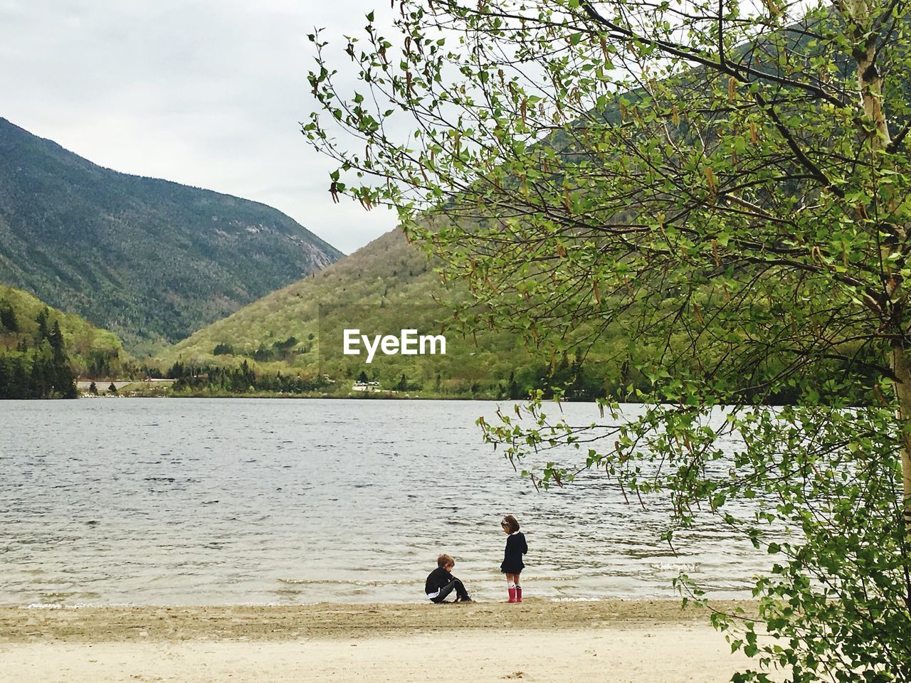 Siblings playing by lake