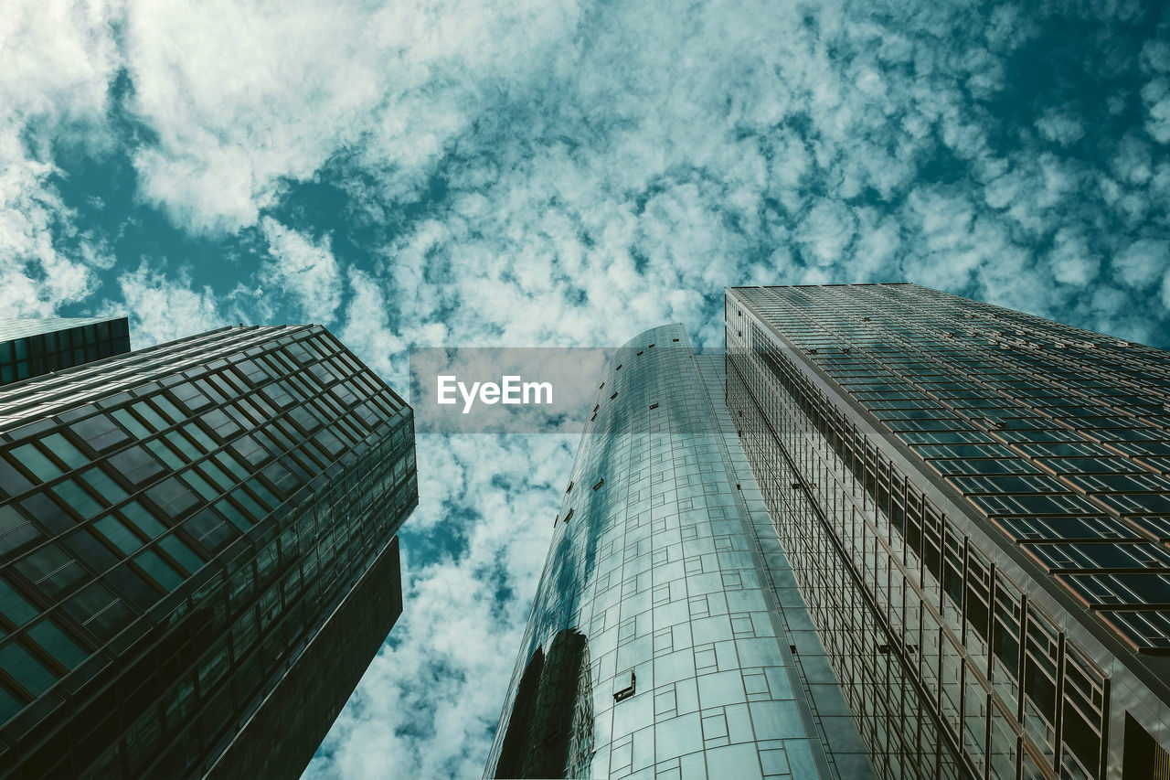 Low angle view of modern glass building against sky