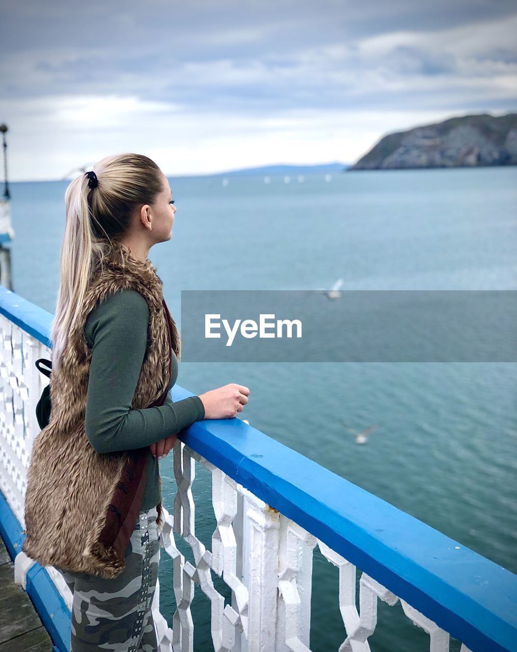 Woman looking at sea against sky