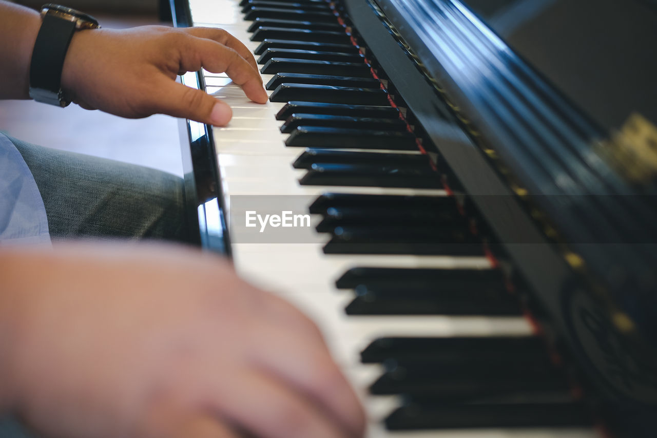 Close-up of man playing piano