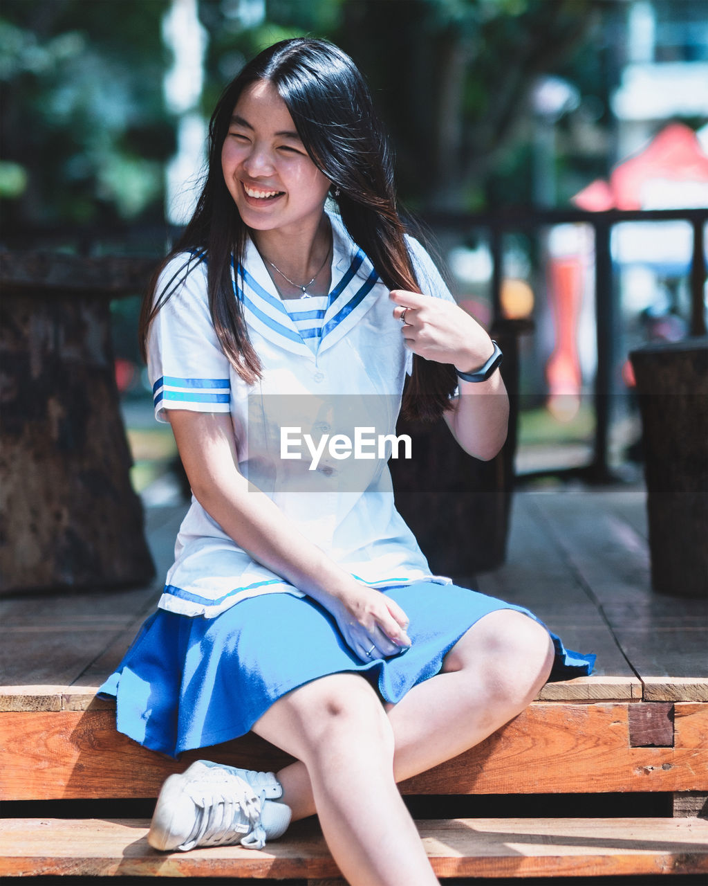 Portrait of smiling young woman sitting outdoors