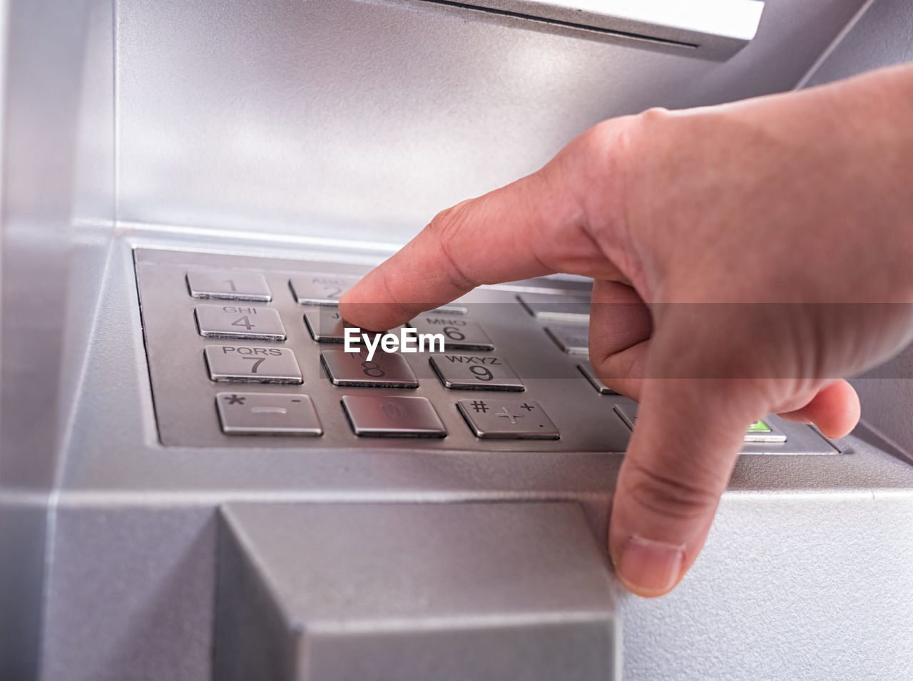 Close-up of person using atm machine