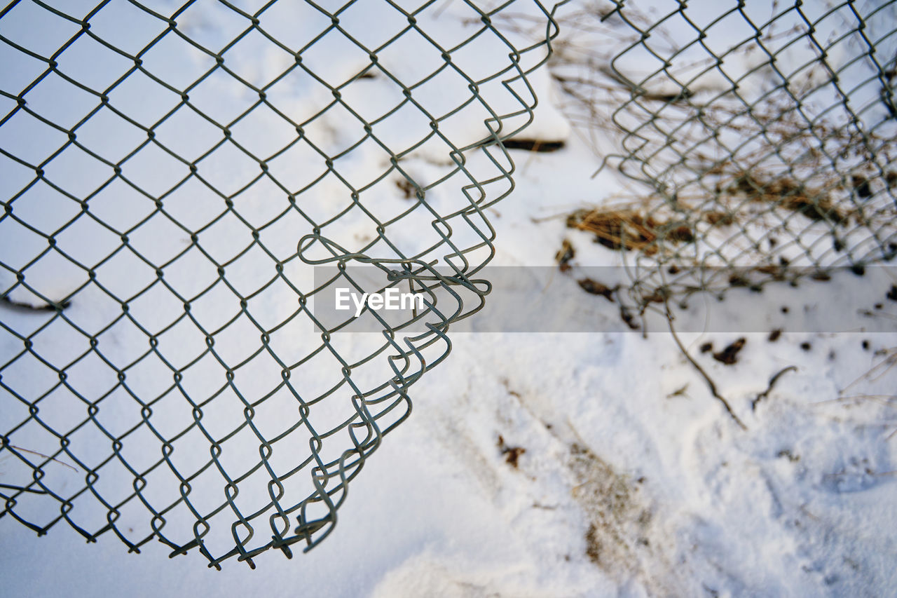 CLOSE-UP OF SNOW ON CHAINLINK FENCE