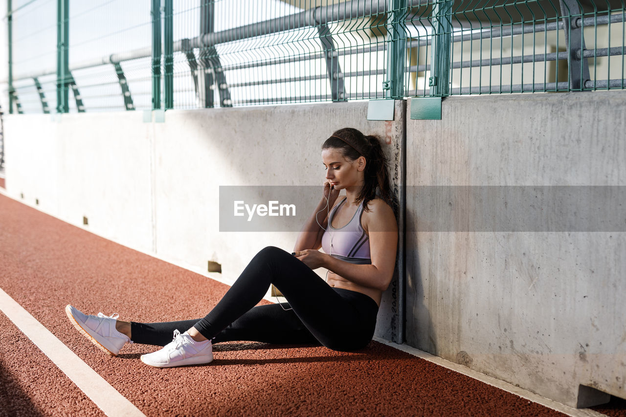 Young woman sitting on running track