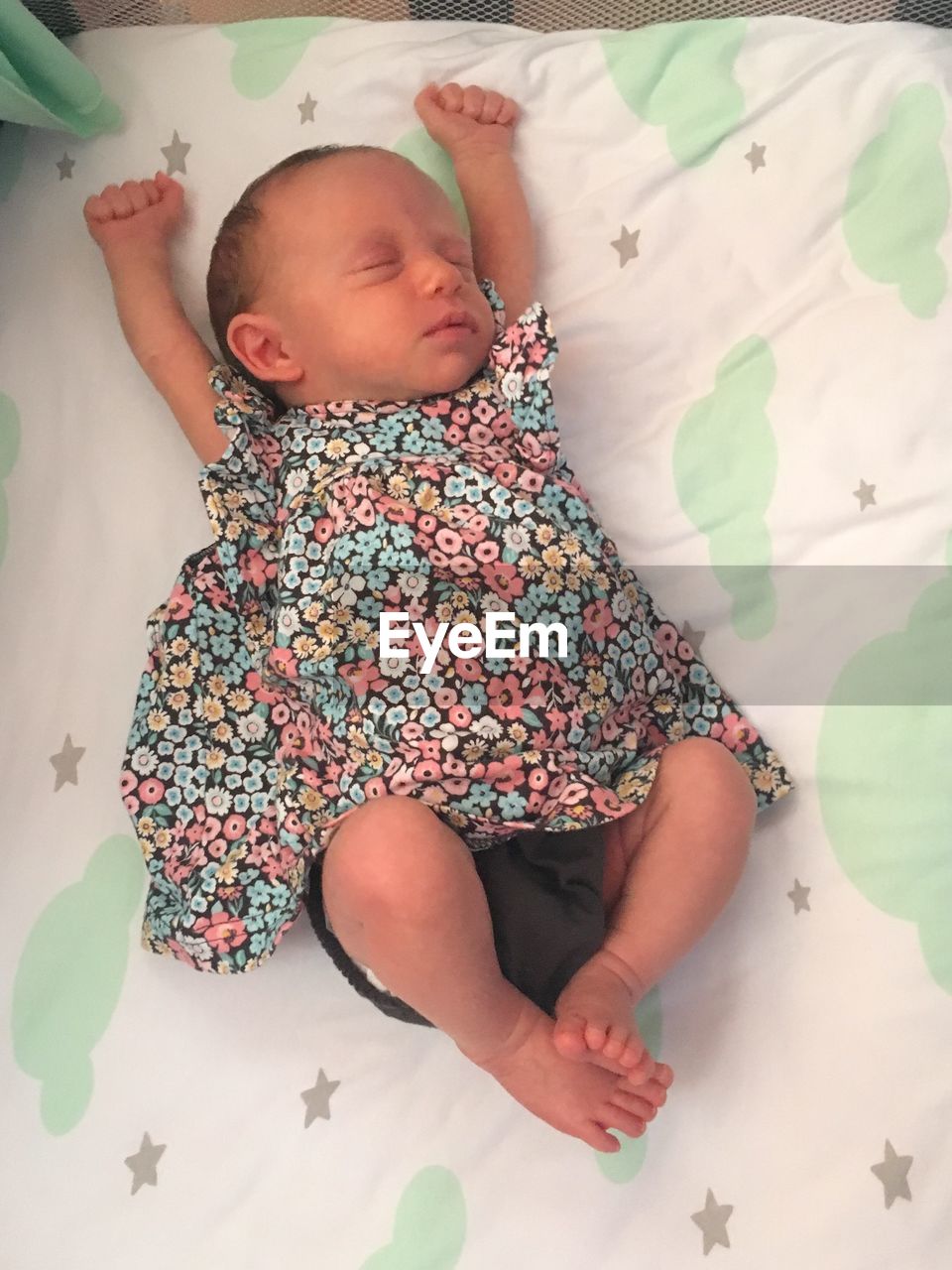 HIGH ANGLE VIEW OF BABY LYING ON BED