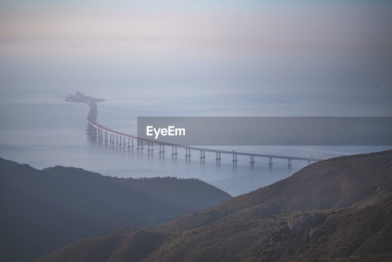 View of bridge over sea against cloudy sky