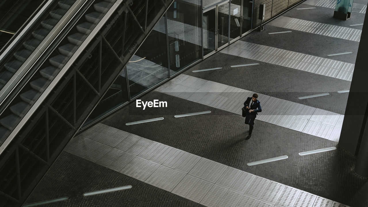 High angle view of businessman walking on footpath