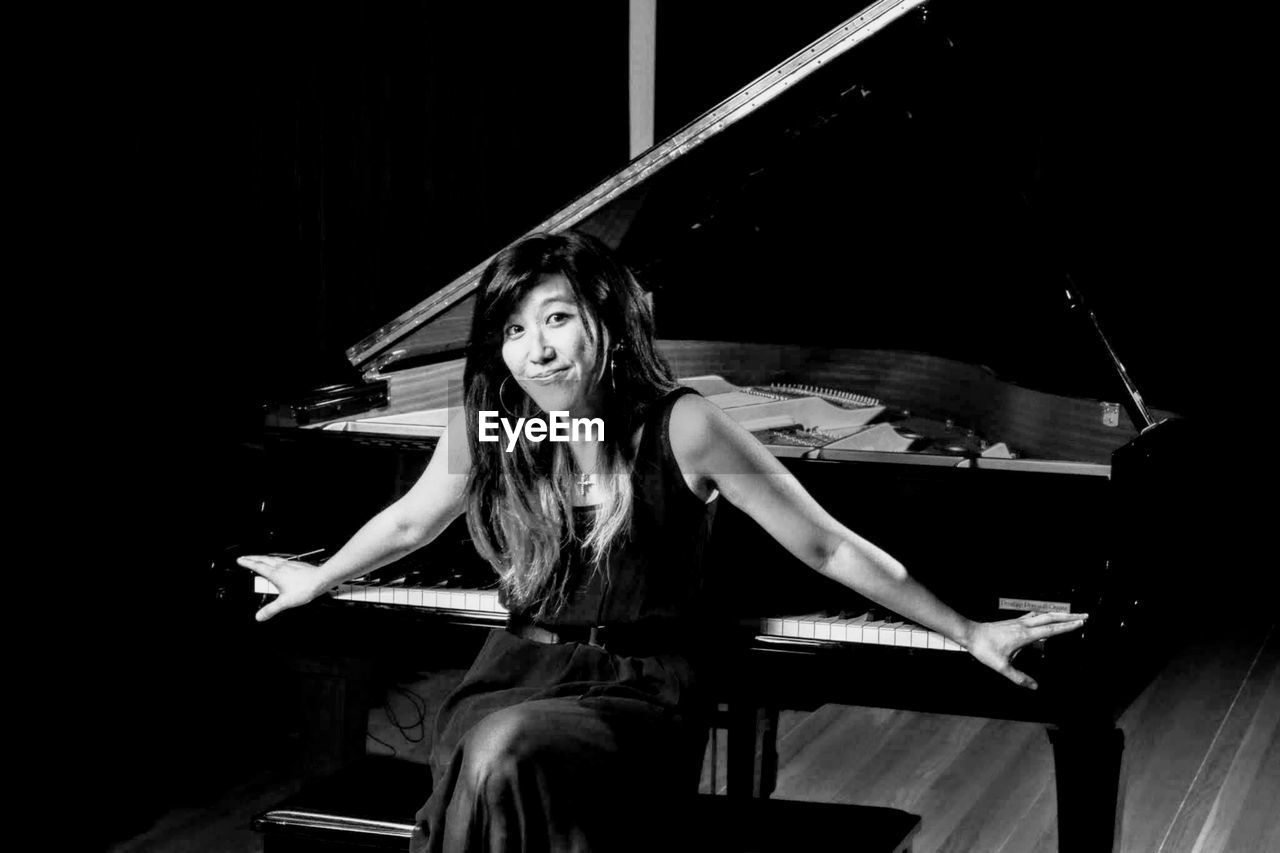 Portrait of young woman sitting on stage beautiful lady, piano, grant, pianist, black and white