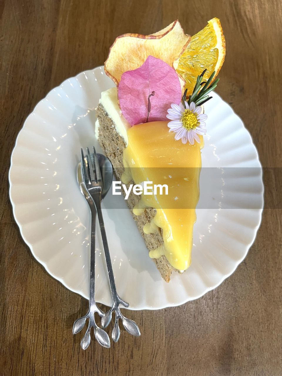 food, food and drink, plate, sweet food, freshness, fork, sweet, dessert, eating utensil, cake, kitchen utensil, table, flower, baked, still life, produce, indoors, flowering plant, slice, no people, temptation, icing, fruit, birthday cake, close-up, high angle view, yellow, wood, plant, slice of cake, nature, dish, healthy eating, gourmet