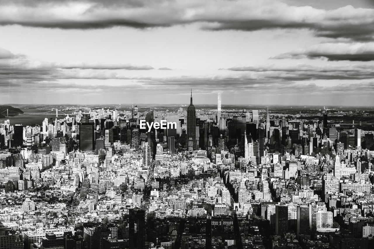 View of cityscape against cloudy sky