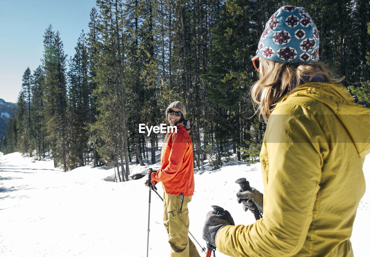 Two young women cross-country ski on mt. hood on a sunny day.