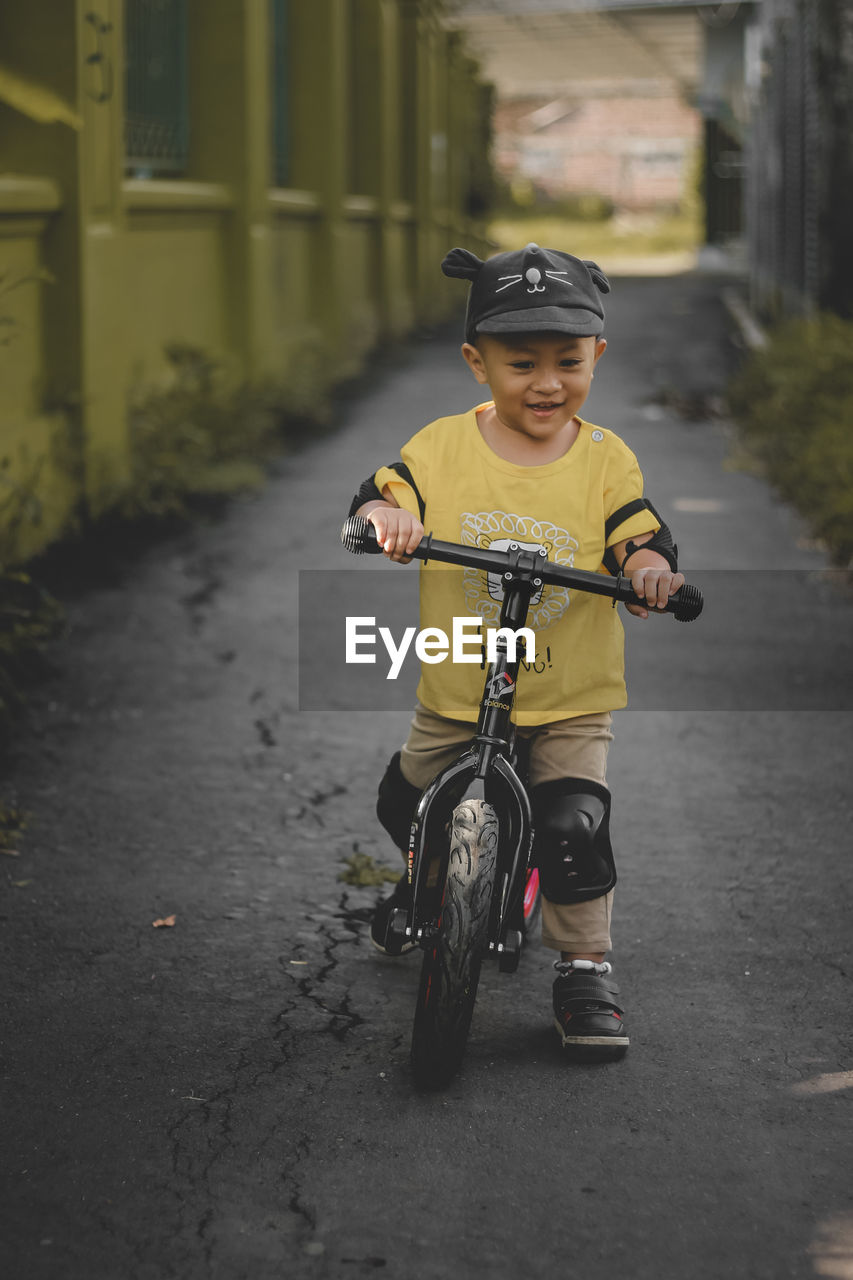 Portrait of cute 2 year old toddler riding a push bike