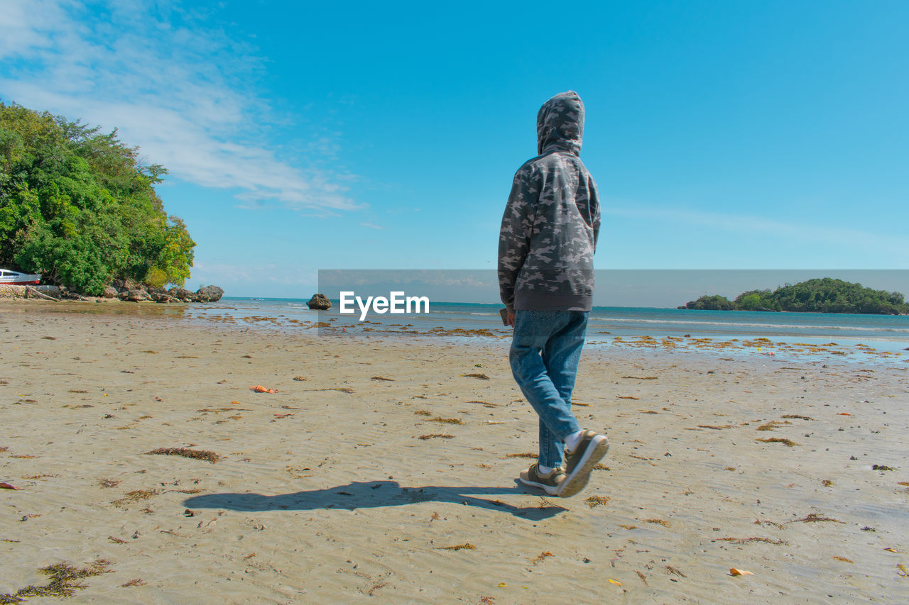 Rear view of man standing at beach