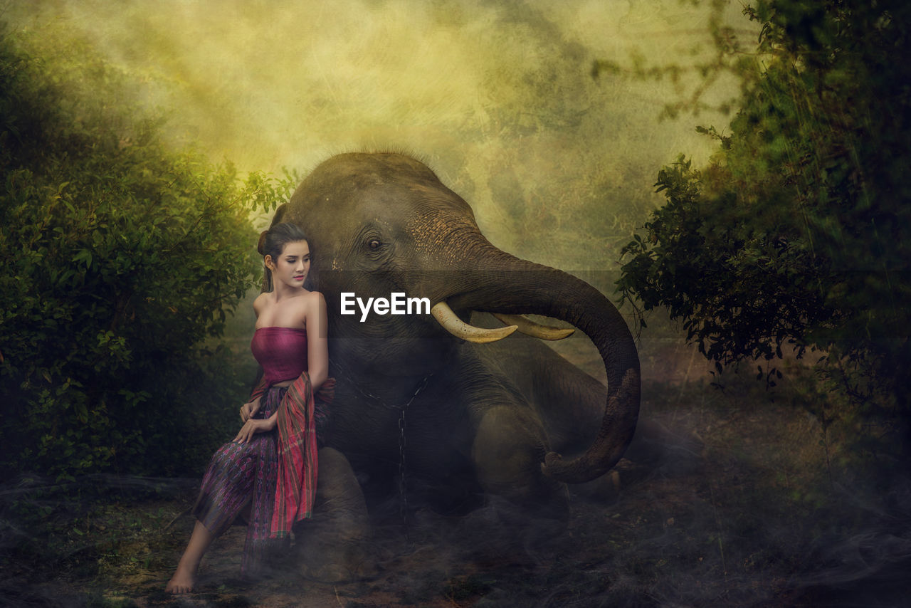 FULL LENGTH OF WOMAN ON ELEPHANT