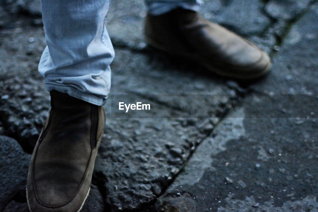 Low section of man standing on paving stones