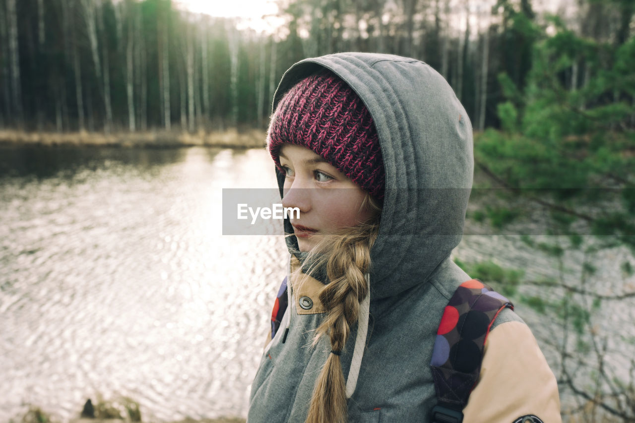 Beautiful girl in warm clothes by the river