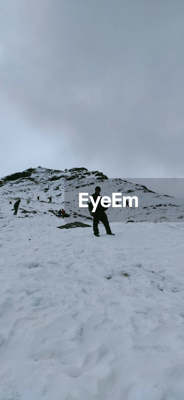 Rear view of woman walking on snow covered landscape