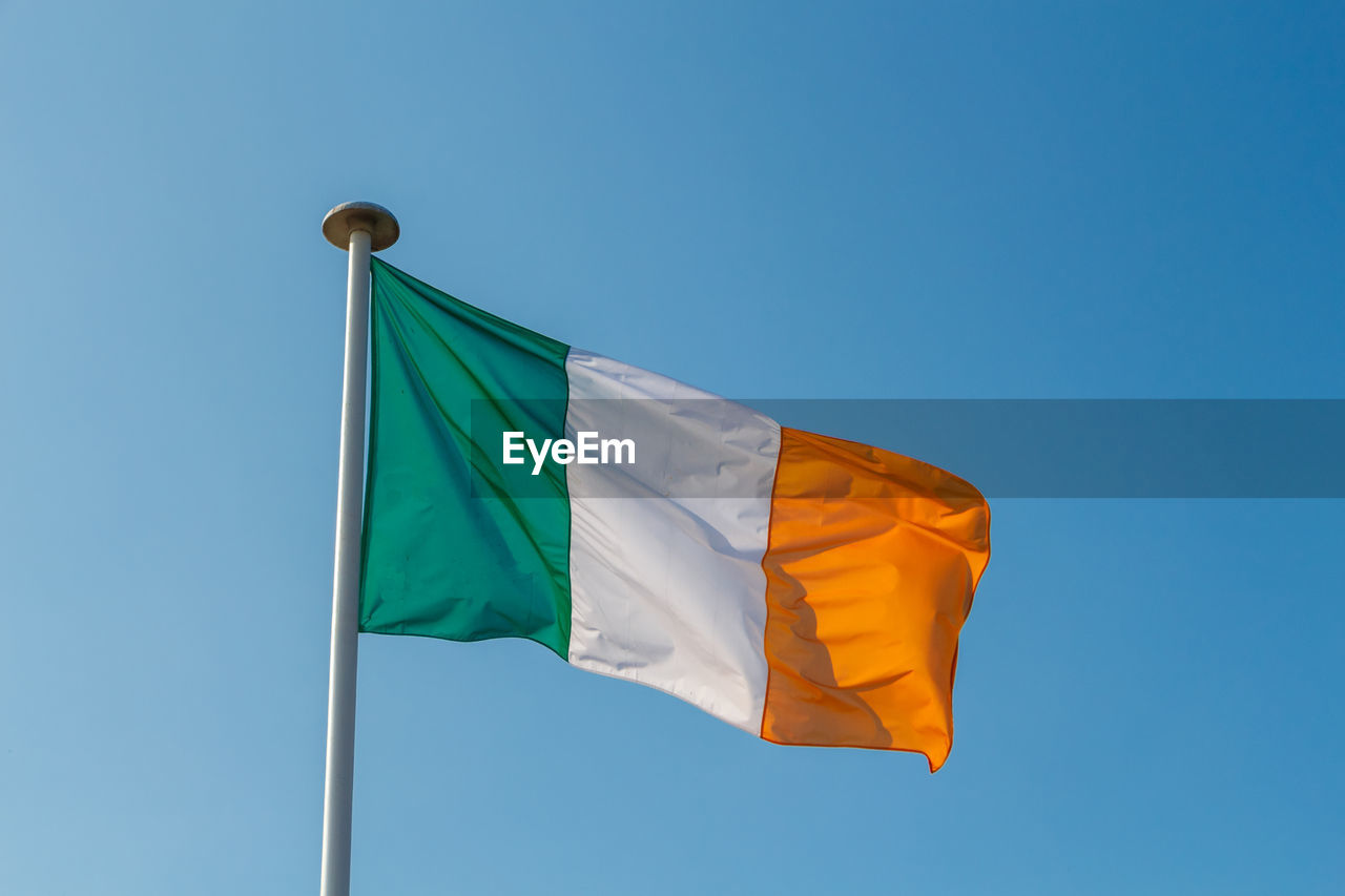 Low angle view of irish flag against clear sky