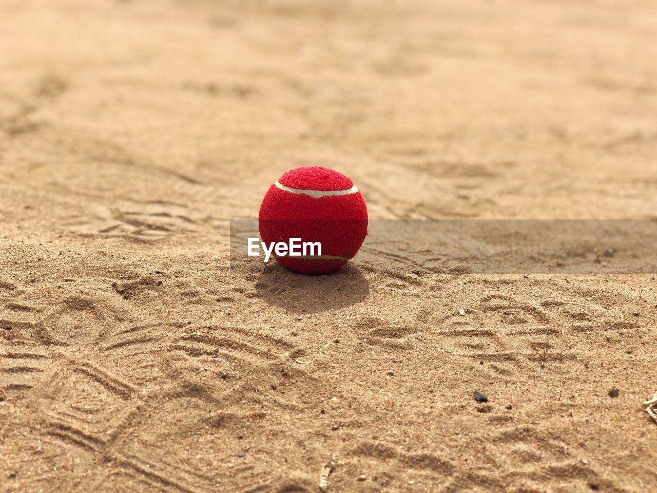 Close-up of red ball on sand