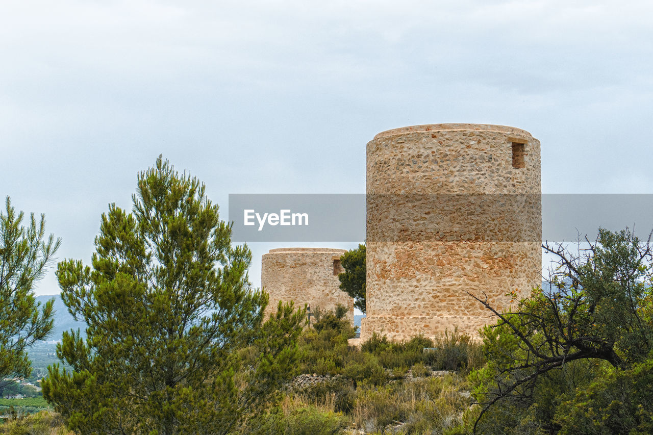 architecture, built structure, plant, sky, history, tree, the past, building exterior, cloud, nature, ruins, building, fortification, no people, castle, tower, rural area, outdoors, fort, day, low angle view, ancient, travel destinations, old, landmark, wall, travel, old ruin, industry