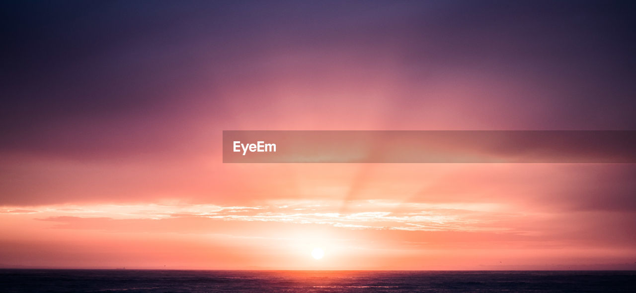 VIEW OF SEA AGAINST ROMANTIC SKY AT SUNSET