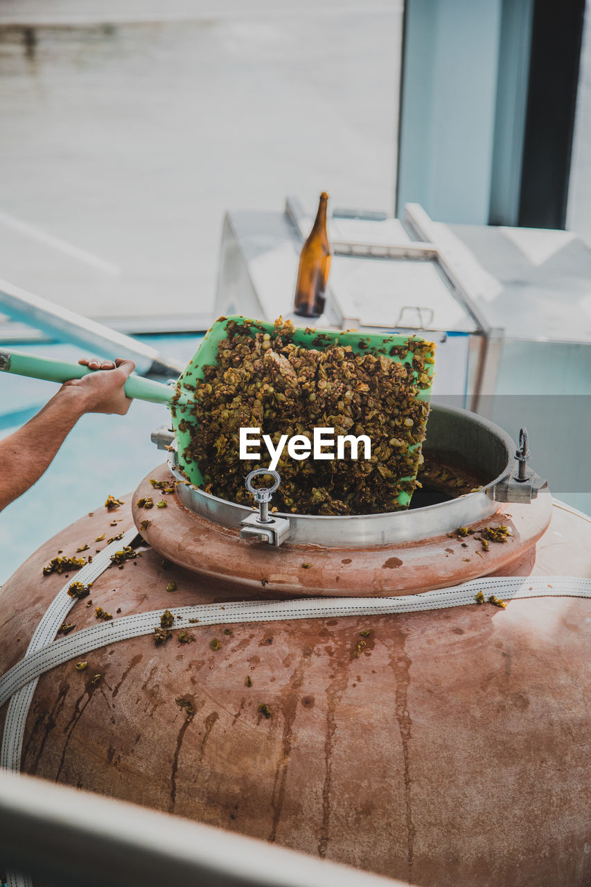 Close-up of hand putting food in container