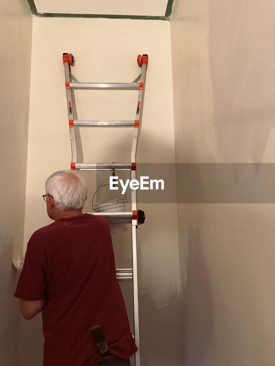 REAR VIEW OF MAN STANDING IN RED WALL