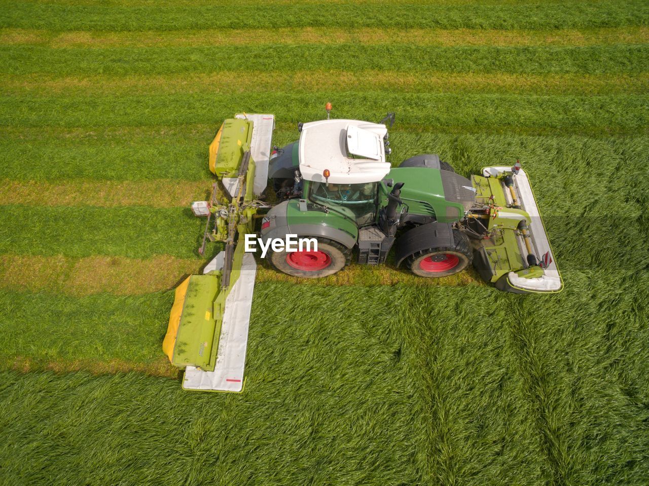 HIGH ANGLE VIEW OF TRACTOR ON FIELD DURING FARM