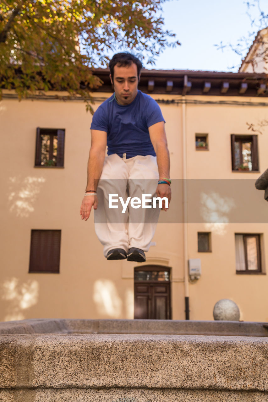 Full length of man jumping in artificial pond