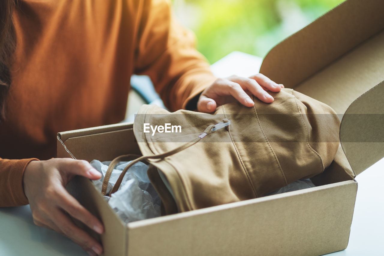 midsection of man with suitcase