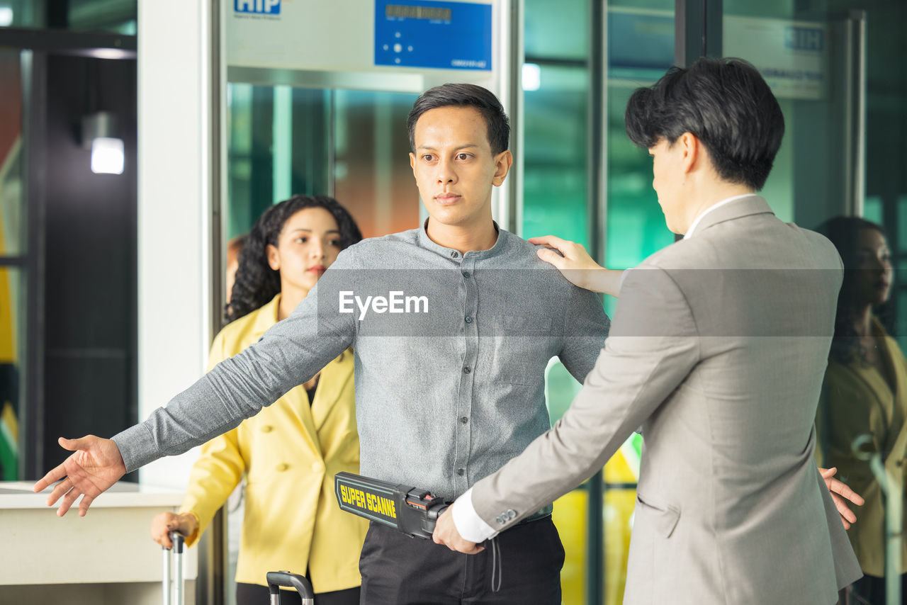 In the airport, people are going through the physical screening and luggage scanning procedures.