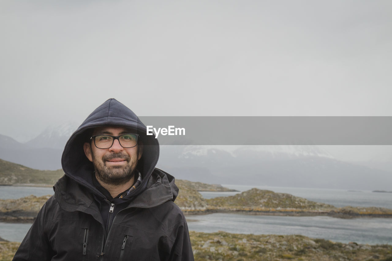 Portrait of young man standing against mountain