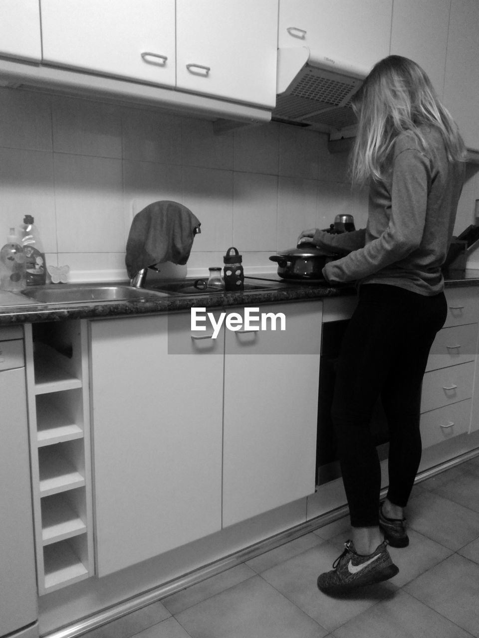 FULL LENGTH OF SENIOR WOMAN STANDING IN FRONT OF KITCHEN