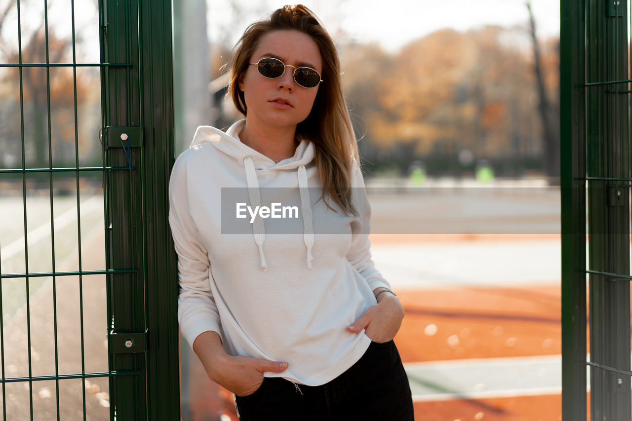 Portrait of young woman wearing sunglasses standing outdoors